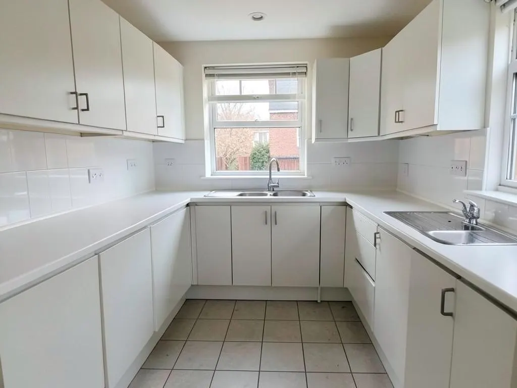 Empty rental kitchen with clean worktops, cupboard fronts and sink ready for a new tenant moving in