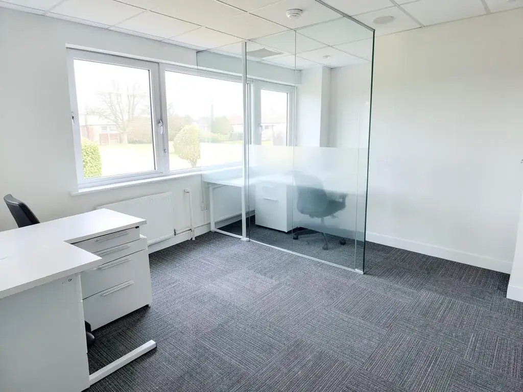 Small office after cleaning with clear desks, carpet tiles and glass partitions